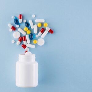Pote com medicamentos que formam um coração sobre a mesa.