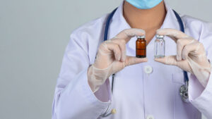 Médica segurando dois frascos de Palivizumabe, medicamento indicado para prevenção de infecções respiratórias graves