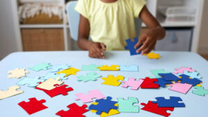 Criança com autismo montando quebra-cabeça colorido, representando o direito ao reembolso do tratamento