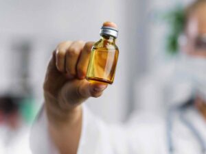 Mulher com medicamento na mão, alusão ao tratamento com Spinraza, medicamento de alto custo