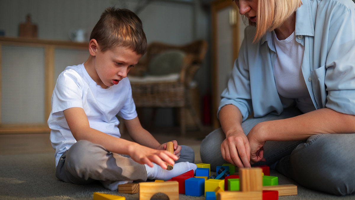 Criança com autismo em terapia ABA acompanhada por profissional especializada, ilustrando o direito à cobertura pelo plano de saúde.